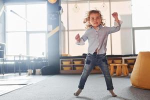 un enfant en vêtements décontractés s'amuse dans la salle de jeux le week-end photo