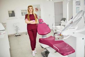 jeune femme dentiste en uniforme debout dans le bureau de stomatologie photo