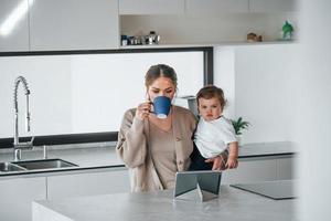 mère blogueuse avec son enfant ensemble à l'intérieur à la maison le week-end à l'aide d'une tablette photo