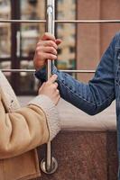 vue rapprochée des mains de la femme et de l'homme qui tiennent une balustrade argentée au moment de la quarantaine photo