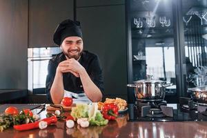 processus de préparation. jeune chef cuisinier professionnel en uniforme travaillant dans la cuisine photo