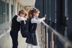 un petit écolier vole des choses dans le sac d'une fille pendant qu'elle écoute de la musique photo