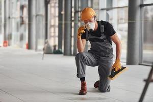 homme en uniforme gris posant pour une caméra à l'intérieur dans un grand bureau moderne pendant la journée photo