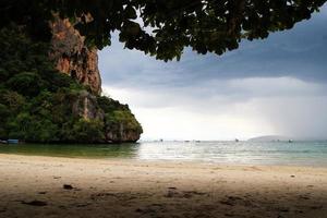 voyage à krabi, thaïlande. la vue sur une plage avec des falaises par temps nuageux depuis la plage de railay. photo