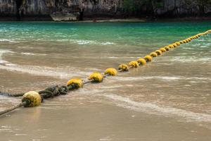 voyage à krabi, thaïlande. la vue panoramique sur la mer avec des bouées jaunes et un rocher de la plage de phra nang. photo