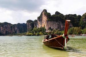 voyage à krabi, thaïlande. la vue sur le long bateau sur une côte de mer depuis la plage de railay. photo