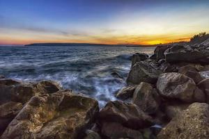 coucher de soleil sur la mer. gros rochers au premier plan photo