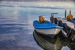 bateau avec reflet de l'eau le soir d'été sur un quai photo