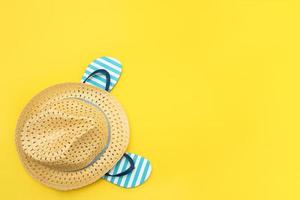 accessoires de plage - chapeau de paille et tongs sur fond jaune, fond d'été, espace de copie photo