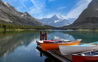 canoës colorés sur la rive du lac mcdonald dans le parc national des glaciers du montana. photo