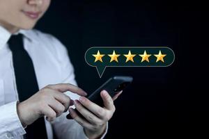 note de service notes de satisfaction des clients, commentaires ou critiques positives. les clients utilisent des smartphones pour noter cinq étoiles. satisfaire le service. les notes sont très impressionnantes photo