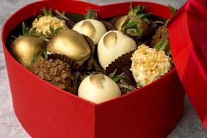 Boîte en forme de coeur avec un assortiment de fraises enrobées de chocolat sur un fond gris.st valentine's,concept de la fête des mères photo