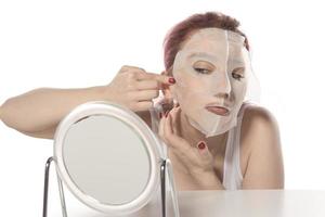 procédure cosmétique. visage de femme avec masque cosmétique blanc photo