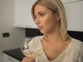 jolies femmes blondes buvant du vin par une fenêtre. photo