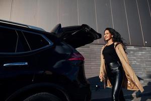 jeune femme en leggins noirs sort de sa voiture moderne photo