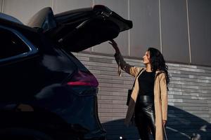 jeune femme en leggins noirs sort de sa voiture moderne photo