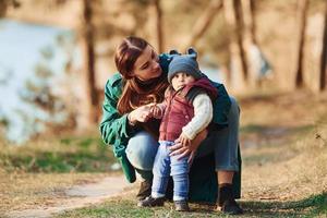 mère avec son petit fils se promener dans la forêt de printemps pendant la journée photo