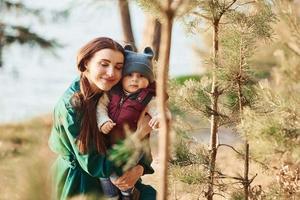 mère avec son petit fils se promener dans la forêt de printemps pendant la journée photo