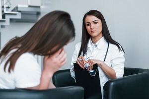 la fille a une dépression mentale et pleure. une jeune femme rend visite à une femme médecin dans une clinique moderne photo