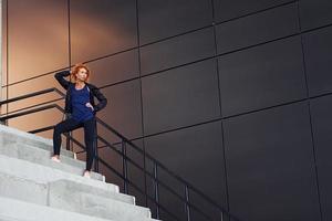 jeune femme rousse européenne a marcher dans les escaliers à l'extérieur photo