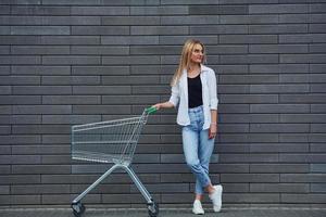 belle blonde en vêtements décontractés avec panier est à l'extérieur pendant la journée ensoleillée photo