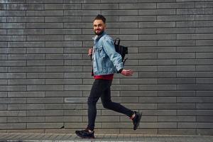 beau jeune homme en vêtements décontractés est à l'extérieur pendant la journée ensoleillée photo