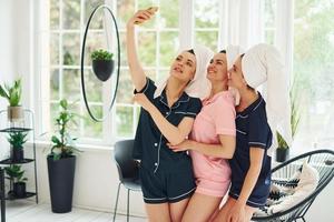 joyeuses jeunes femmes en pyjama s'amusant à l'intérieur pendant la journée ensemble photo