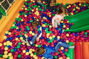 des enfants heureux en vêtements décontractés s'amusent dans un complexe de jeux pour enfants photo