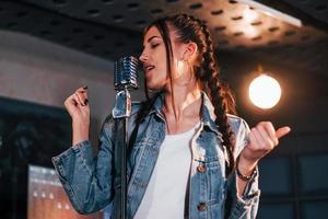 jeune belle interprète féminine répétant dans un studio d'enregistrement photo