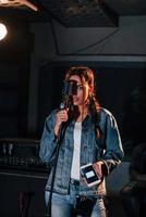 jeune belle interprète féminine répétant dans un studio d'enregistrement photo