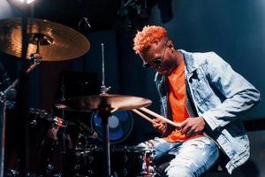 joue de la batterie. jeune artiste afro-américain répétant dans un studio d'enregistrement photo