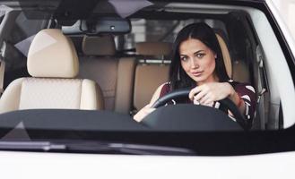 belle jeune brune à l'intérieur de l'automobile moderne. voiture d'équitation photo