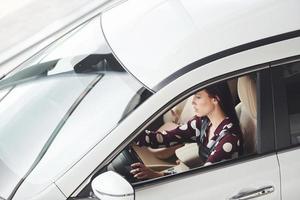 vue latérale de la belle jeune brune à l'intérieur de l'automobile moderne. voiture d'équitation photo