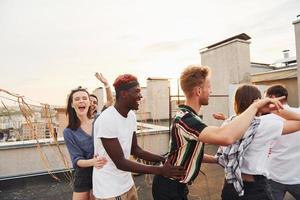 temps de récréation. un groupe de jeunes en vêtements décontractés fait la fête ensemble sur le toit pendant la journée photo