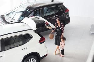 mère avec sa fille marchant ensemble près de l'intérieur de l'automobile moderne photo