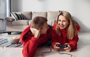 jeune couple charmant ensemble à la maison jouant à des jeux vidéo le week-end et les vacances ensemble photo
