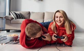 jeune couple charmant ensemble à la maison jouant à des jeux vidéo le week-end et les vacances ensemble photo