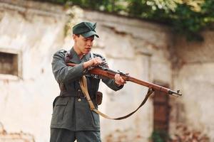 ternopil, ukraine - juin 2020 upa tournage d'un film de l'armée insurrectionnelle ukrainienne. photos des coulisses. jeune soldat avec arme près du vieux bâtiment