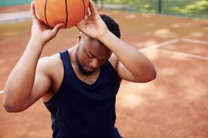 un homme afro-américain joue au basket sur le terrain à l'extérieur photo