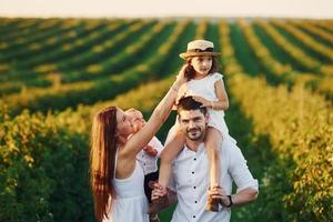 au champ agricole. père, mère avec fille et fils passant du temps libre à l'extérieur aux beaux jours de l'été photo