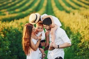 au champ agricole. père, mère avec fille et fils passant du temps libre à l'extérieur aux beaux jours de l'été photo