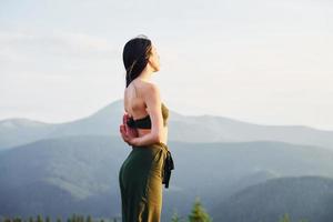 femme sportive aime faire du yoga. majestueuses montagnes des carpates. beau paysage de nature intacte photo