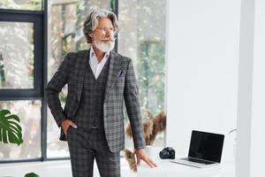 homme d'affaires au bureau. homme moderne et élégant aux cheveux gris et à la barbe à l'intérieur photo