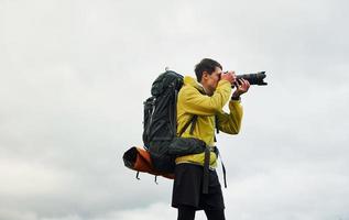 jeune photographe masculin avec son appareil photo professionnel prenant des photos de la belle nature