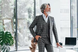 homme d'affaires au bureau. homme moderne et élégant aux cheveux gris et à la barbe à l'intérieur photo