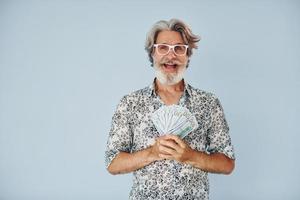 millionnaire avec de l'argent en mains. homme moderne et élégant aux cheveux gris et à la barbe à l'intérieur photo