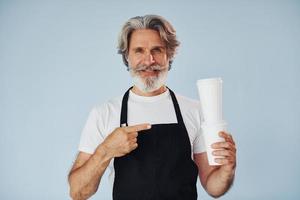 serveur avec des boissons dans les mains. homme moderne et élégant aux cheveux gris et à la barbe à l'intérieur photo