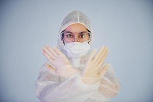 arrêter le signe du virus. portrait d'une femme médecin scientifique en blouse de laboratoire, lunettes défensives et masque photo