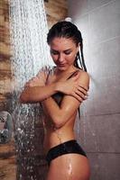 jolie brune avec un type de corps mince sexy en sous-vêtements prenant une douche dans un spa photo