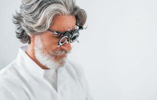 un homme âgé aux cheveux gris et à la barbe est en clinique d'ophtalmologie photo